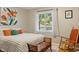 Inviting bedroom showcases a comfortable bed with colorful pillows and a sunny window at 3904 Haverhill Dr, Indianapolis, IN 46240