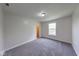 Cozy bedroom featuring gray carpet, white trim, and a window offering natural light at 4055 Steelewater Way, Indianapolis, IN 46235
