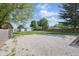 Spacious backyard with mature trees and gravel parking area at 410 W Douglas St, Martinsville, IN 46151