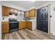 Functional kitchen features wooden cabinets, modern appliances, neutral countertops, and vinyl flooring at 410 W Douglas St, Martinsville, IN 46151