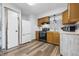 Efficient kitchen features wooden cabinets, modern appliances, neutral countertops, and durable vinyl flooring at 410 W Douglas St, Martinsville, IN 46151