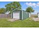 Green shed in a backyard with a white garage door and space for storage at 410 W Douglas St, Martinsville, IN 46151