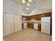 Functional kitchen with ample cabinet space, white appliances, and neutral tile flooring at 413 Woodberry Dr, Danville, IN 46122