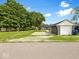 View of the house's backyard with a detached garage, driveway, and trees at 429 Colescott St, Shelbyville, IN 46176