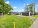 View of the backyard featuring a detached garage and a well-maintained lawn, perfect for outdoor activities at 429 Colescott St, Shelbyville, IN 46176