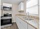 Well-lit kitchen featuring granite countertops, stainless steel oven and modern faucet at 429 Colescott St, Shelbyville, IN 46176