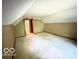 A carpeted bedroom has a sloped ceiling and a view into another room at 4419 Liberty Loop Rd, Martinsville, IN 46151