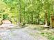 Gravel driveway leading to the detached garage and tan home surrounded by mature trees at 4419 Liberty Loop Rd, Martinsville, IN 46151