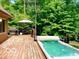 Outdoor deck featuring a built-in hot tub and grilling area, surrounded by lush green trees at 4419 Liberty Loop Rd, Martinsville, IN 46151