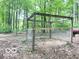 An enclosure with wood beam supports and wire fencing, located in a wooded area at 4419 Liberty Loop Rd, Martinsville, IN 46151