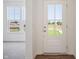 Bright foyer with a white front door, hardwood flooring, and views of the outdoors through windows at 4785 E Shadowbrook Dr, Camby, IN 46113