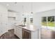 Modern kitchen island with stainless steel dishwasher and view to the sliding glass door at 4785 E Shadowbrook Dr, Camby, IN 46113