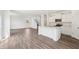 Open-concept living area features hardwood floors, white walls, and a kitchen with stainless steel appliances at 4785 E Shadowbrook Dr, Camby, IN 46113