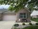 Charming brick home featuring a cozy front porch with a decorative bench and landscaping at 5486 Lipizzan Ln, Plainfield, IN 46168