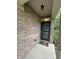 Covered front porch with brick and a green front door at 5486 Lipizzan Ln, Plainfield, IN 46168