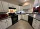Traditional kitchen featuring white cabinets, black appliances, and a breakfast bar overlooking the living area at 5486 Lipizzan Ln, Plainfield, IN 46168