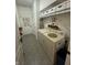 Bright laundry room with front load washer/dryer, shelving, and tile flooring at 5486 Lipizzan Ln, Plainfield, IN 46168