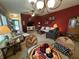Comfortable living room with a stylish chandelier and a vibrant red accent wall at 5486 Lipizzan Ln, Plainfield, IN 46168