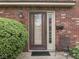 Inviting front entrance with brick surround, accent plants, and seating at 57 Trails End St, Greenwood, IN 46142