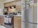 Charming kitchen featuring wooden cabinets, modern microwave, range and fridge, and practical countertop space at 57 Trails End St, Greenwood, IN 46142