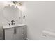 Bathroom featuring a gray vanity with marble countertop, and a round mirror with stylish lighting at 5843 N Oakland Ave, Indianapolis, IN 46220