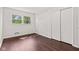 Bedroom featuring hardwood floors, beadboard accent wall, a window, and closet with sliding doors at 5843 N Oakland Ave, Indianapolis, IN 46220