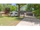 Attractive single-Gathering home featuring a concrete driveway, lush lawn, and mature trees at 5843 N Oakland Ave, Indianapolis, IN 46220