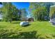 Green backyard with mature trees, a storage shed, and propane tank at 5941 North St, Stilesville, IN 46180