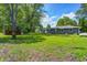 Spacious backyard featuring lush green grass, mature trees, and a storage shed at 5941 North St, Stilesville, IN 46180