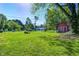 Large backyard showcasing green lawn, mature trees, shed, and a peaceful residential setting at 5941 North St, Stilesville, IN 46180