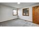 Cozy bedroom with two windows, gray carpet, and a knotty pine closet door at 5941 North St, Stilesville, IN 46180
