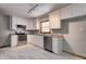Updated kitchen with white cabinets, stainless steel appliances, granite countertops, and sleek marble-patterned tile flooring at 5941 North St, Stilesville, IN 46180