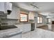 Modern kitchen with white cabinets, stainless steel appliances, granite counters, marble-patterned floors, and open floor plan at 5941 North St, Stilesville, IN 46180