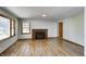 Inviting living room featuring hardwood floors, a cozy brick fireplace, and abundant natural light from large windows at 5941 North St, Stilesville, IN 46180