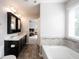 Bathroom featuring a double sink vanity, soaking tub, and a seamless transition to the bedroom at 635 Sonoma Ln, Greenfield, IN 46140