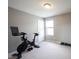Exercise room featuring neutral carpeting and a Peloton exercise bike near a window at 635 Sonoma Ln, Greenfield, IN 46140