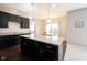 Bright kitchen with dark cabinets and a center island flowing into the dining area at 635 Sonoma Ln, Greenfield, IN 46140