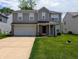 Two-story home with gray siding, a brick-accented garage, and a well-manicured front lawn at 6715 Shanghai Cir, Indianapolis, IN 46278