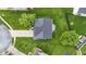 Bird's eye view of a home with a landscaped backyard, patio, driveway, and mature trees at 6822 Woodford Ln, Indianapolis, IN 46237