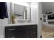 Stylish half-bathroom with navy vanity, white countertop, and decorative mirror above the sink at 6822 Woodford Ln, Indianapolis, IN 46237