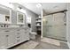 A spacious bathroom featuring a white vanity, glass shower and gray tiling at 6822 Woodford Ln, Indianapolis, IN 46237