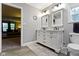 A well-lit bathroom features a double vanity, tiled floor and open doorway at 6822 Woodford Ln, Indianapolis, IN 46237
