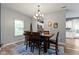 Cozy dining room with a stylish chandelier, wood table, and view into the kitchen at 6822 Woodford Ln, Indianapolis, IN 46237