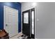 Stylish entryway featuring a decorative front door, blue accent wall, and tile flooring at 6822 Woodford Ln, Indianapolis, IN 46237
