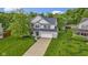 Charming two-story home with a lush green lawn, a long driveway, and curb appeal at 6822 Woodford Ln, Indianapolis, IN 46237