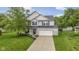 Charming two-story home with a brick facade, well-manicured lawn, and attached two-car garage at 6822 Woodford Ln, Indianapolis, IN 46237