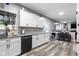 Well-lit kitchen featuring white cabinets, stainless steel appliances and an adjacent dining area at 6822 Woodford Ln, Indianapolis, IN 46237