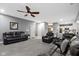 Comfortable living room with gray walls, plush carpet, ceiling fan and open access to the kitchen at 6822 Woodford Ln, Indianapolis, IN 46237