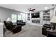 Cozy living room with a fireplace, built-in shelving, and comfortable leather seating at 6822 Woodford Ln, Indianapolis, IN 46237