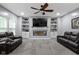 Comfortable living room featuring a fireplace, built-in shelves, and plenty of natural light at 6822 Woodford Ln, Indianapolis, IN 46237